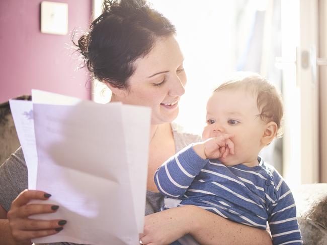 A young mother reads through a legal pack from her insurance company or solicitor. She is making provisions for the future of her child. life insurance generic, family protection