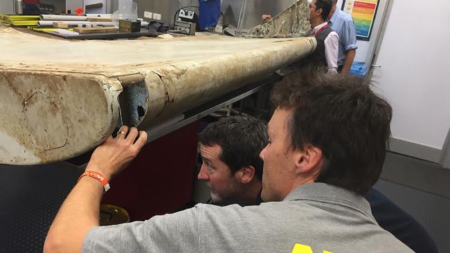 CORRECTION - This undated handout photo released by the Australia Transport Safety Bureau on July 20, 2016 shows Malaysian and Australian investigators in Canberra examining a piece of aircraft debris found on Pemba Island off the coast of Tanzania. Transport ministers from Australia, China and Malaysia will meet July 22, 2016 to discuss the future of the frustrating deep-sea search for missing flight MH370, officials said July 20. / AFP PHOTO / ATSB / Handout / RESTRICTED TO EDITORIAL USE - MANDATORY CREDIT "AFP PHOTO / AUSTRALIA TRANSPORT SAFETY BUREAU" - NO MARKETING NO ADVERTISING CAMPAIGNS - DISTRIBUTED AS A SERVICE TO CLIENTS == NO ARCHIVE / “The erroneous mention[s] appearing in the metadata of this photo by Australia Transport Safety Bureau has been modified in AFP systems in the following manner: adding CANBERRA as location. Please immediately remove the erroneous mention[s] from all your online services and delete it (them) from your servers. If you have been authorized by AFP to distribute it (them) to third parties, please ensure that the same actions are carried out by them. Failure to promptly comply with these instructions will entail liability on your part for any continued or post notification usage. Therefore we thank you very much for all your attention and prompt action. We are sorry for the inconvenience this notification may cause and remain at your disposal for any further information you may require.”