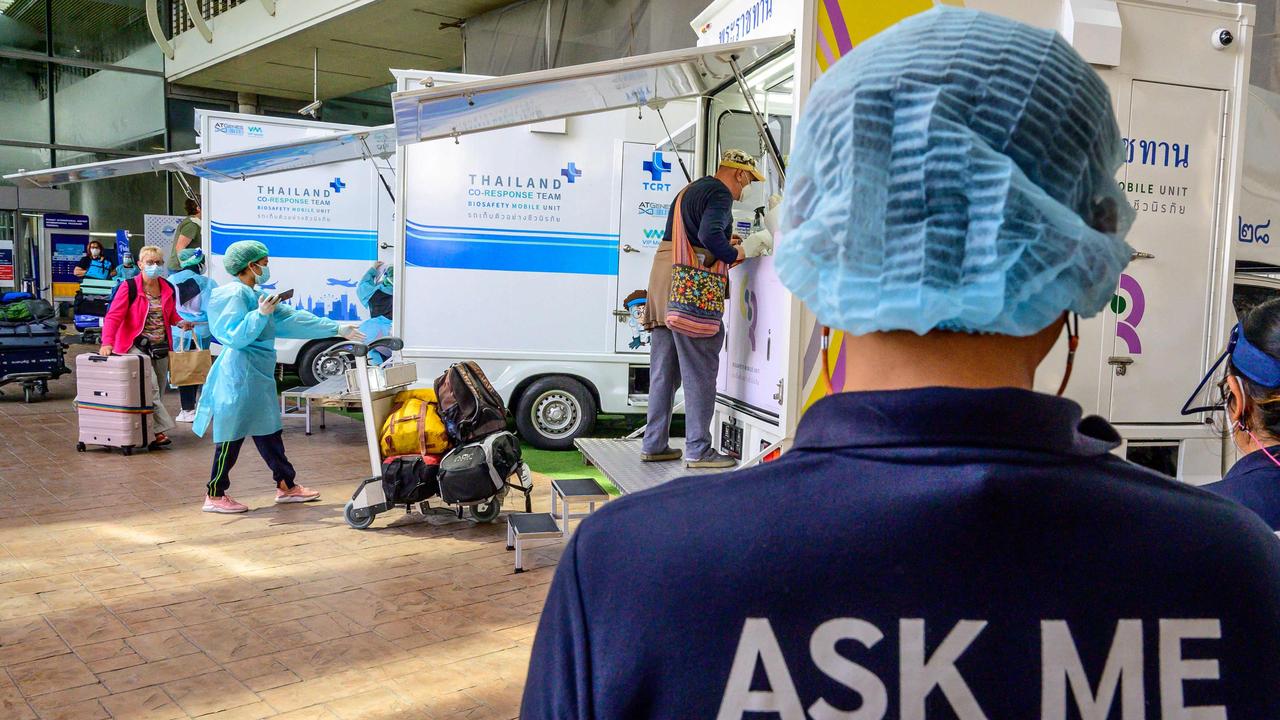 An airport employee assists passengers through the arrival area at Phuket International Airport as Thailand welcomes the first group of tourists fully vaccinated against the Covid-19 coronavirus without quarantine in Phuket. Picture: Mladen Antonov / AFP