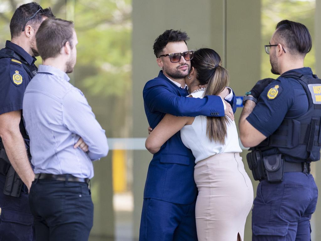 Giovanni Genuario embraces his partner, as he is confronted by Australian Boarder Force officers as he leaves court.