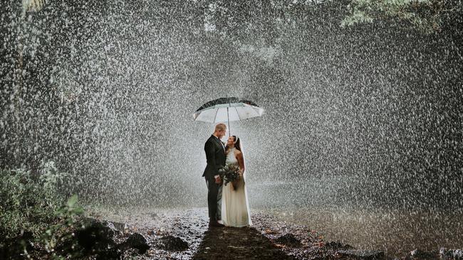 Sarah and Eric Morris embracing the rain, and each other, at Goomboora Park. Picture: Perspectives Photography