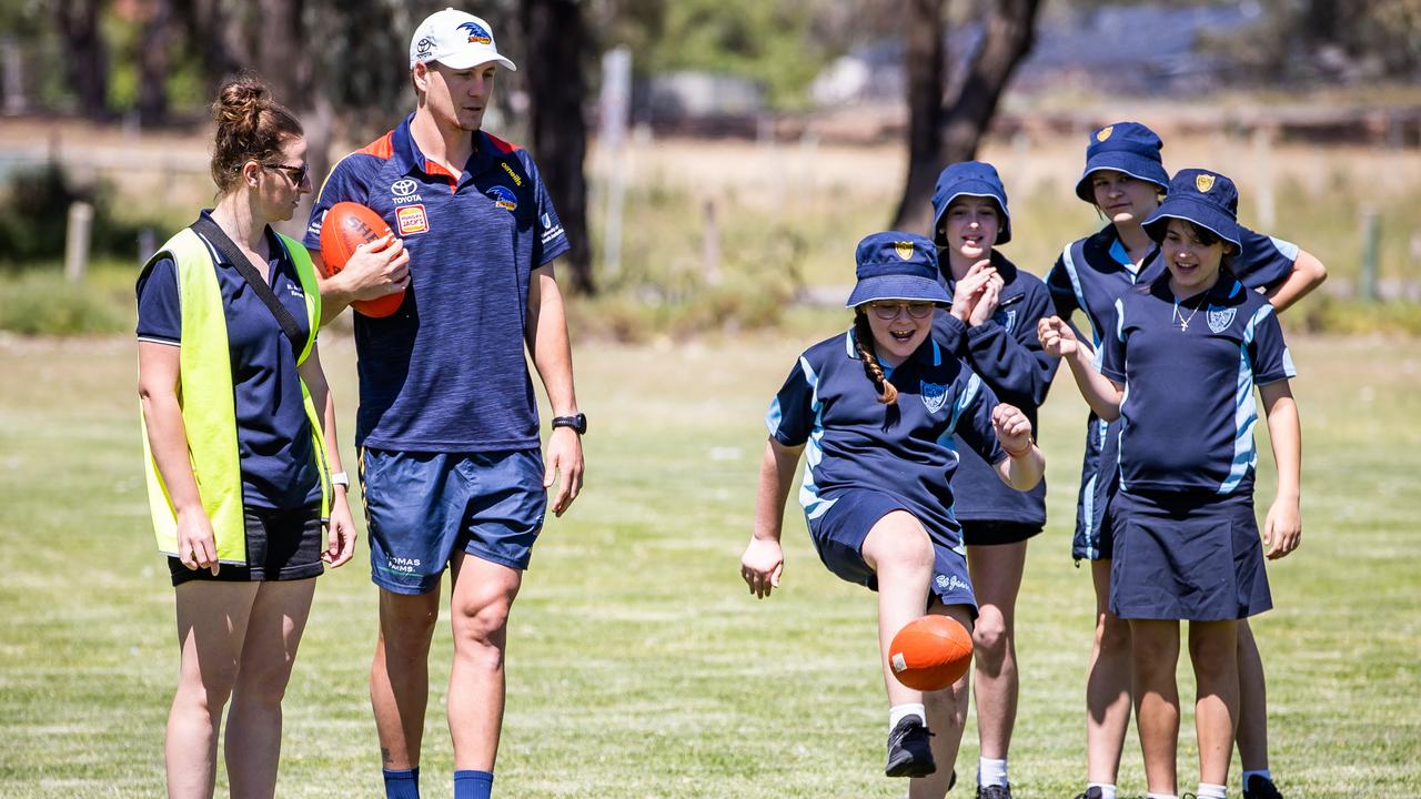 Crow Jordan Dawson kicks the footy with kids from Renmark High. Picture: Tom Huntley