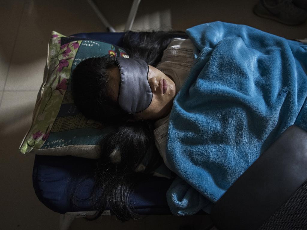 A portable cot. A blanket, and goggles. This employee’s bed is her cubicle. Picture: Getty