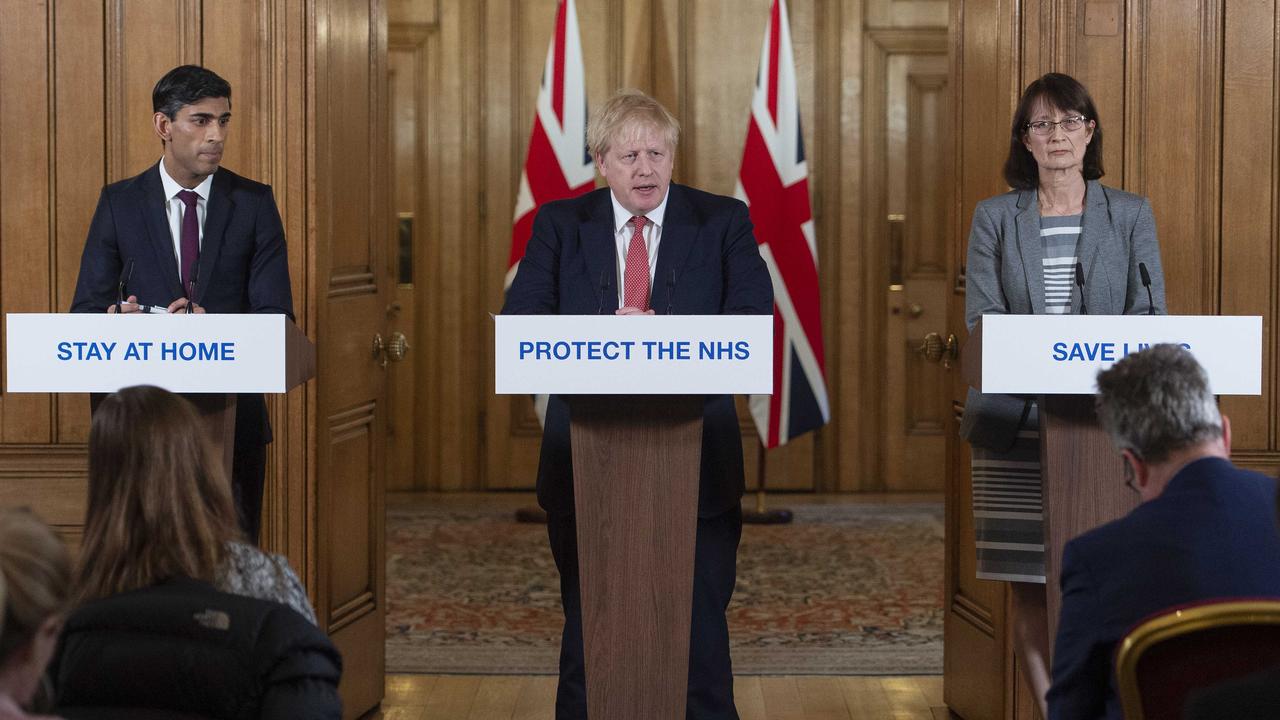 Chancellor of the Exchequer Rishi Sunak (L) and Deputy Chief Medical Officer Dr Jenny Harries (R) look on as British Prime Minister Boris Johnson (C) speaks in London on Friday. Picture: Julian Simmonds/WPA Pool/Getty Images