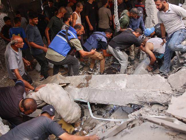 People sift through debris after a school used as shelter by displaced Palestinians was hit by an Israeli strike in the Shujaiya neighbourhood of Gaza City on September 18, 2024, amid the ongoing war between Israel and the militant group Hamas. (Photo by Omar AL-QATTAA / AFP)