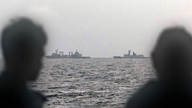 TOPSHOT - This handout photo taken on February 13, 2025 and released by The Australian Defence Force shows sailors onboard the Royal Australian Navy ship HMAS Arunta looking at the People's Liberation Army-Navy (PLA-N) Fuchi-class replenishment vessel and Weishanhu Jiangkai-class frigate Hengyang in the Tasman Sea. Australia's foreign minister voiced concern on February 21 over live fire drills conducted by three Chinese warships sailing off the country's east coast. (Photo by Handout / AUSTRALIAN DEFENCE FORCE / AFP) / RESTRICTED TO EDITORIAL USE - MANDATORY CREDIT "AFP PHOTO /  AUSTRALIAN DEFENCE FORCE" - NO MARKETING NO ADVERTISING CAMPAIGNS - DISTRIBUTED AS A SERVICE TO CLIENTS