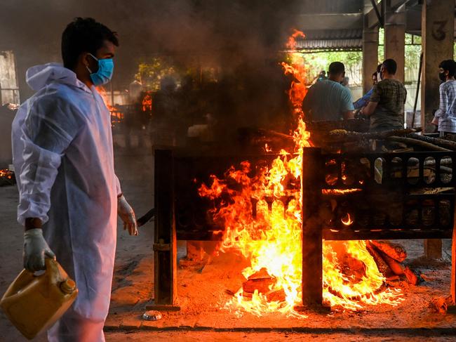 A crematorium staff lights a pyre of a coronavirus victim. Picture: AFP