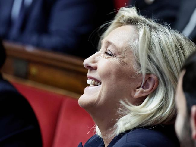 The President of Rassemblement National parliamentary group Marine Le Pen laughs during the voting session on the draft of the Social Security bill 2025 at the National Assembly, the French Parliament's lower house, in Paris on December 2, 2024. French Prime Minister faces the biggest risk yet of being deposed by a hostile National Assembly as his government on December 2, 2024, presents a social security financing plan that has the opposition up in arms. These include planned cuts in employer social contributions, a partial end to inflation-indexing of pensions and a less generous prescription drug reimbursement policy. (Photo by STEPHANE DE SAKUTIN / AFP)