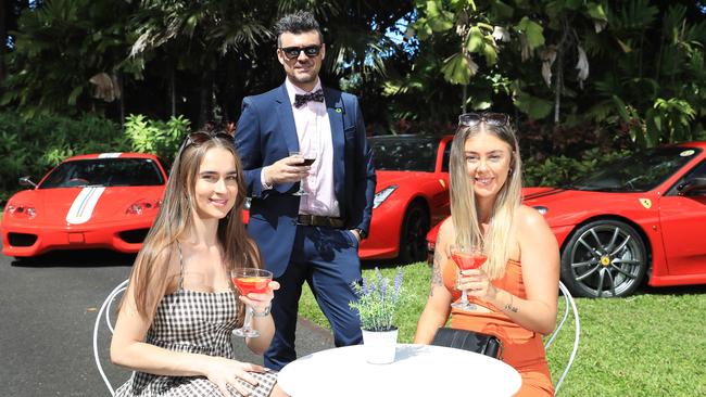 Chelsea Williamson, Claudio Di Bartolomeo and Lily Hayes enjoy cocktails beside some Ferraris. Picture: Brendan Radke