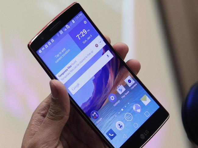 A man photographs the LG G Flex 2 during a media preview before CES International Sunday, Jan. 4, 2015, in Las Vegas. The phone has a curved screen, as the name implies.(AP Photo/John Locher)