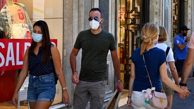 Shoppers wearing face masks walk along the Via del Corso in Rome. Picture: AFP