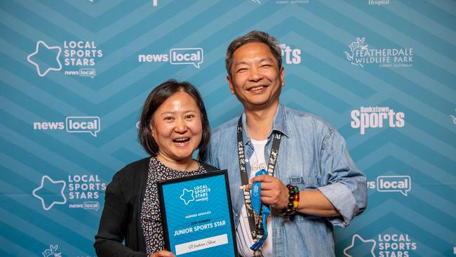 Patty Zhang and Steven Shen pose for a photo with their daughter Wenhan Shen’s award.