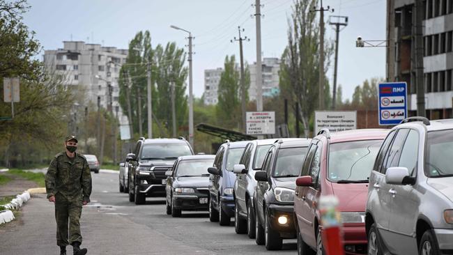 A Transnistrian serviceman walks past a line of car queuing to exit the self-proclaimed ‘Moldovan Republic of Transnistria’ at Varnita border point with Moldova last week. Picture: AFP