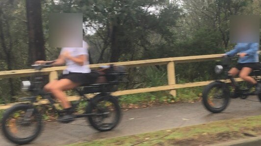 Two girls on e-bikes on the shared pedestrian path on Pittwater Rd, Manly. They were wearing helmets Picture: Jim O’Rourke