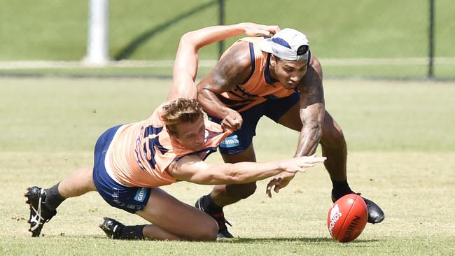 Tim Kelly, right, fights for the football at Geelong training.