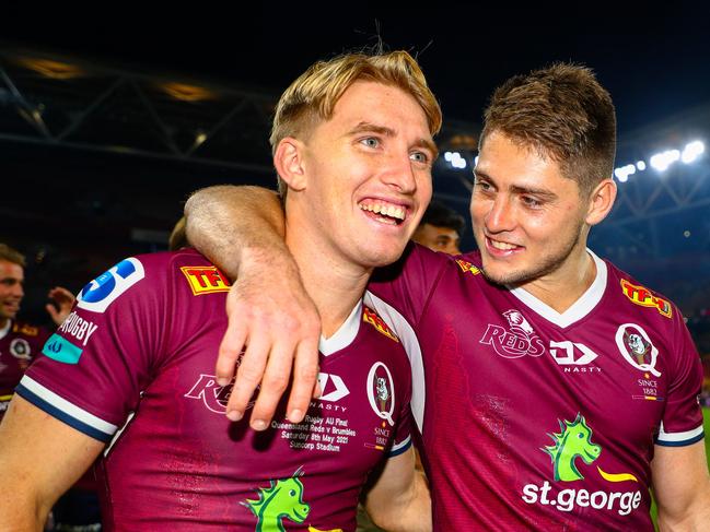 James O'Connor (right) celebrates the Reds’ Super Rugby AU title win with teammate Tate McDermott. Picture: Patrick Hamilton / AFP