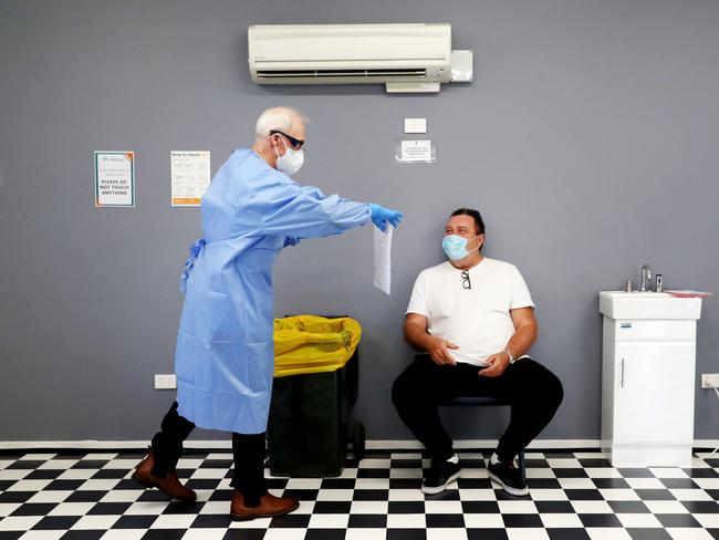 Dr Philip Hayes about to test a patient at the Erina clinic. Picture: Sue Graham