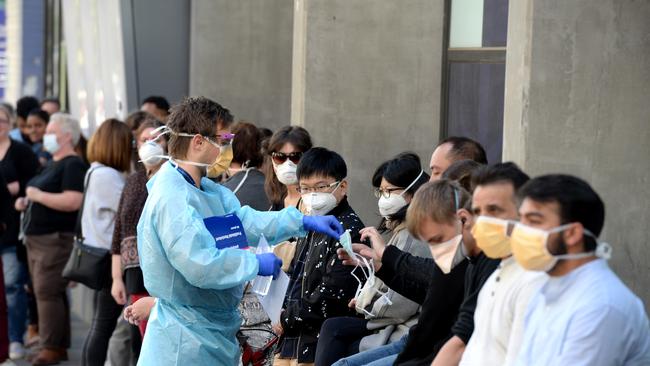 People queue outside the Royal Melbourne Hospital waiting to be tested for the coronavirus. Picture: Andrew Henshaw