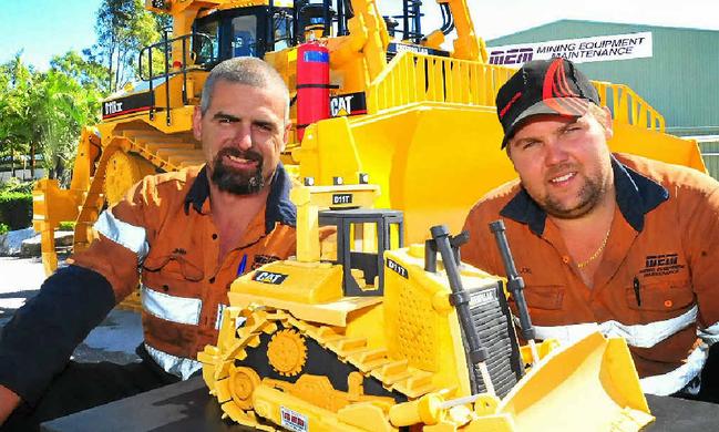 HARD WORK: Mining Equipment Maintenance fitters Jimmy Drennan and Joel Maanen check over a D11 cake dwarfed by a huge D11 Dozer, their most recently completed project. Picture: Contributed