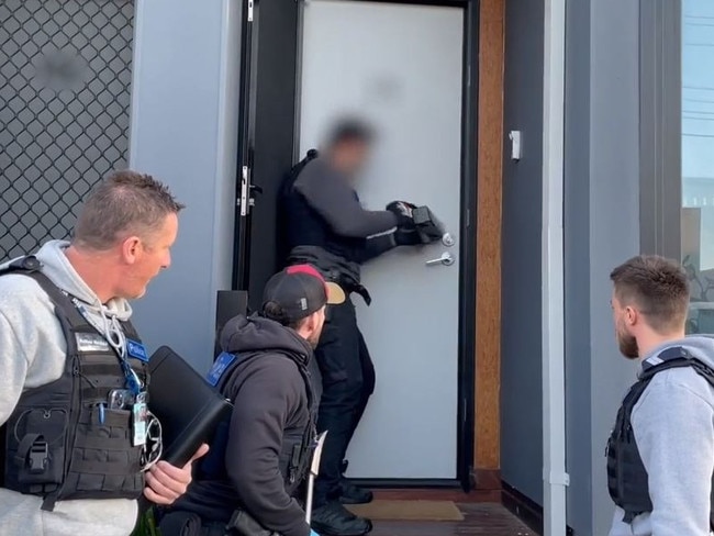 Police smash through the Frankston door. Picture: Victoria Police