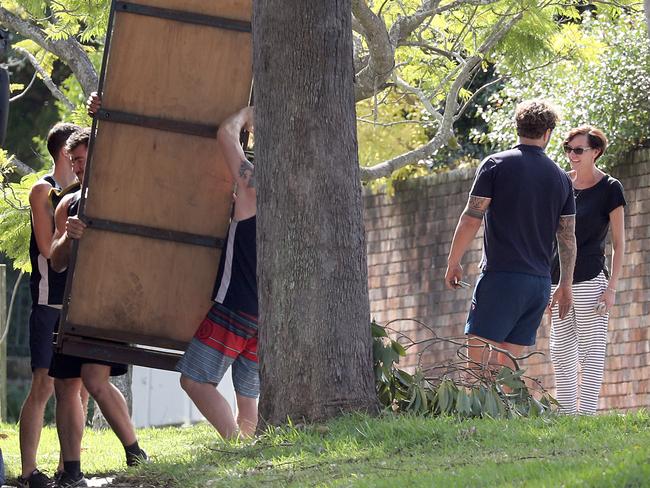 Removalists help move a wardrobe to the truck while Thorburn watches on.