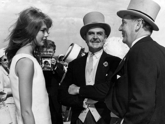 Jean Shrimpton chats to  VRC Committee men F. Gilder (left) and P.J.R. Steele at Flemington on Derby Day.