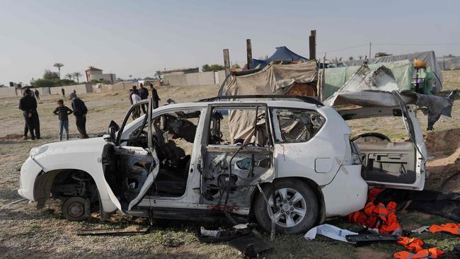 People gather around the carcass of a World Central Kitchen car. Picture: AFP