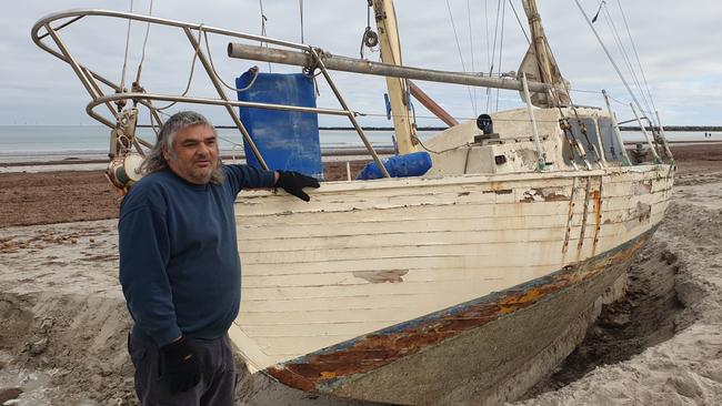 Novice sailor Claude Evans with his stranded yacht at North Haven. Picture: Colin James