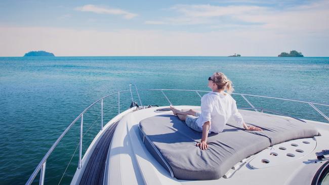 beautiful woman enjoying luxurious yacht cruise, sea travel by luxury boat; rich lifestyle wealth generic