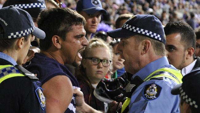 Colour from the Preliminary Final between the Fremantle dockers and Hawthorn Hawks at Domain Stadium in Subiaco. pictured - a fan ( Cody Yarran ) is led away by police after starting a fight during the game