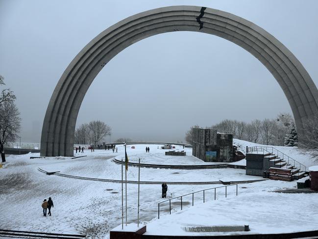 People walk through the snow at The Arch of Freedom of the Ukrainian people in Kyiv, Ukraine as 40 per cent of the city is without power. Picture: Getty Images.