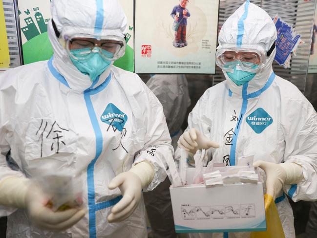 Medical staff members collect samples to be tested for Covid at a quarantine hotel in Lianyungang, China. Picture: AFP