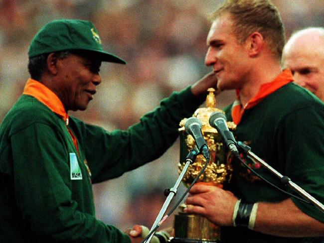 24/06/1995. South African President Nelson Mandela (L) hands over William Webb Ellis Cup trophy to Springboks captain Francois Pienaar after his team defeated All Blacks in Rugby World Cup final, South Africa v New Zealand at Ellis Park in Johannesburg.      General / With Others         Sport / Rugby Union / Trophies