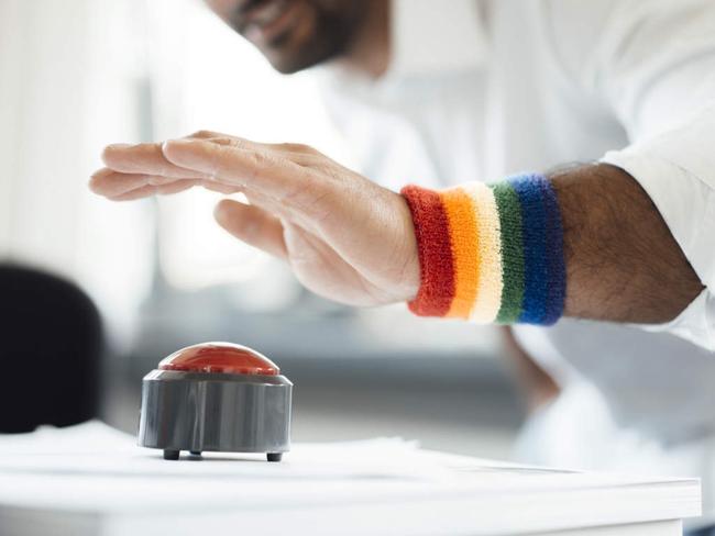 Businessman with hand poised on game show buzzer at office