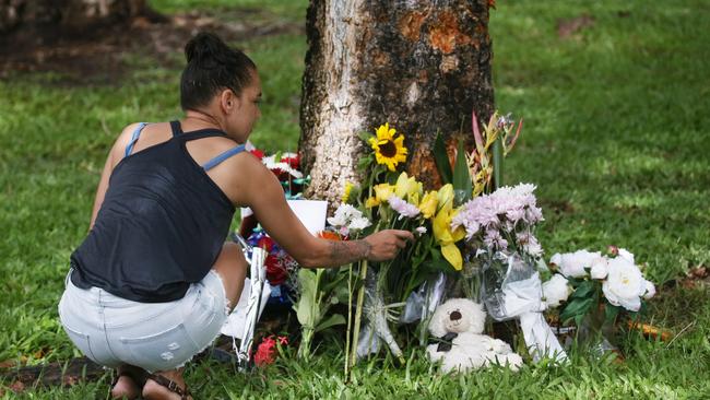 Denise Weazael of Manoora lays some flowers at the scene of a fatal car crash at Manoora, where an allegedly stolen Toyota Yaris left Pease St near the Saltwater Creek bridge and hit a tree. Bradley Smith, 14, was declared dead at the scene, and five other children aged 12 to 15 were taken to Cairns Hospital with injuries. Picture: Brendan Radke