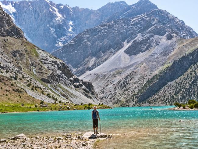 ESCAPE:  Hiker with backpack near Kulikalon lake on rocky mountain background. Fann Mountains, Tajikistan, Central Asia  Picture: Istock