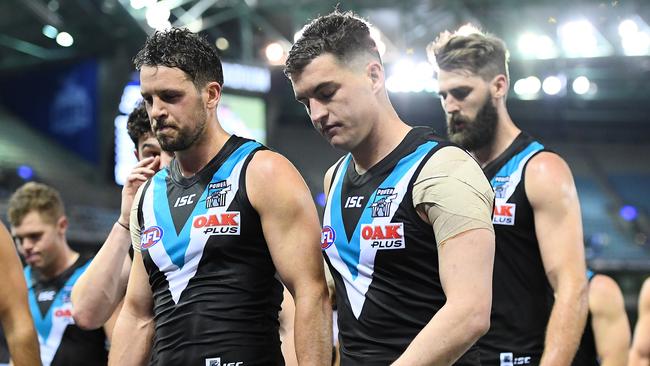 Port Adelaide veterans Travis Boak (left), Tom Rockliff and Justin Westhoff lead their team off the field after the 14-goal smashing to North Melbourne. Picture: QUINN ROONEY (Getty Images).