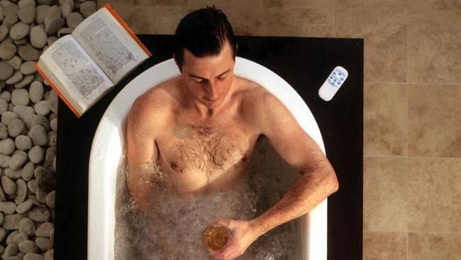 Man sitting in bath using spa Bubble Mat.