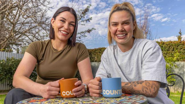 AFLW player Anne Hatchard (right) and wife Georgie … Hatchard says her teammates surrounded her in support when she came out aged 18. Picture: Ben Clark