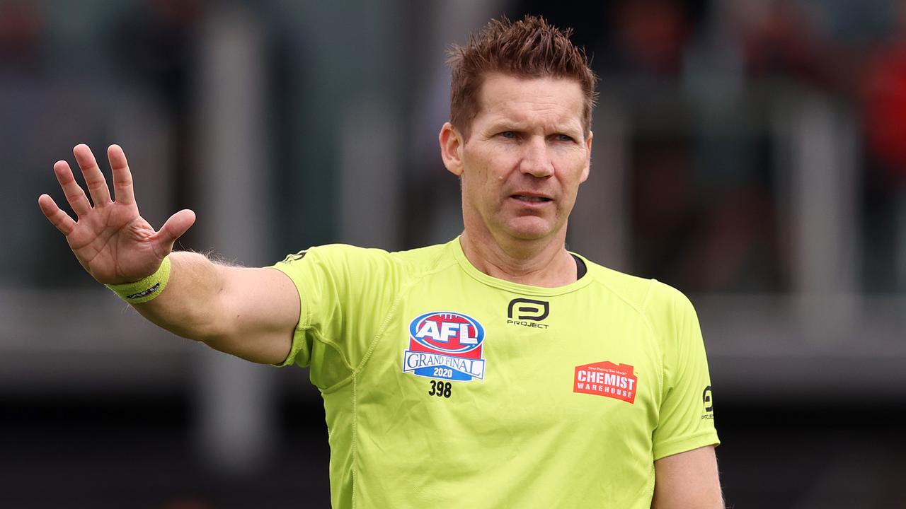 AFL umpire Simon Meredith instructs the player on the mark not to move.