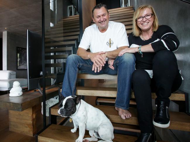 Todd and Roslyn Lyons with their French Bulldog, Tux, at home in Blue Bay on the NSW Central Coast. The couple are selling their property and downsizing in order to travel more.