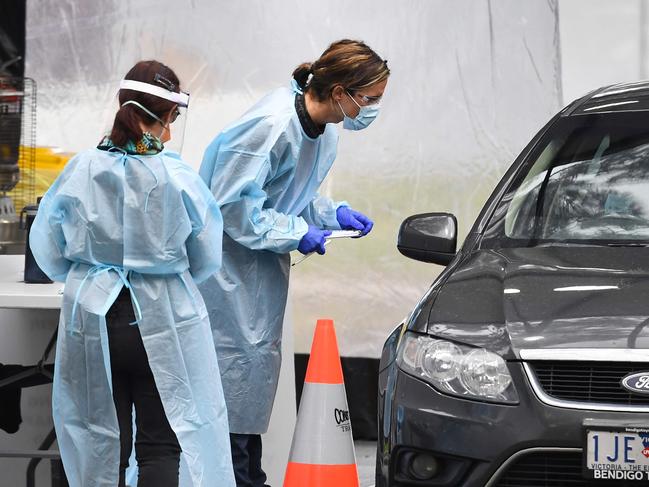 Medical staff prepare to take a swab at a drive-through testing clinic in Melbourne on August 13, 2020. - Australia's virus-hit Victoria state reported a major drop in new coronavirus cases on August 13, but officials warned against complacency amid a "worrying" spread of the disease in regional areas outside Melbourne. (Photo by William WEST / AFP)