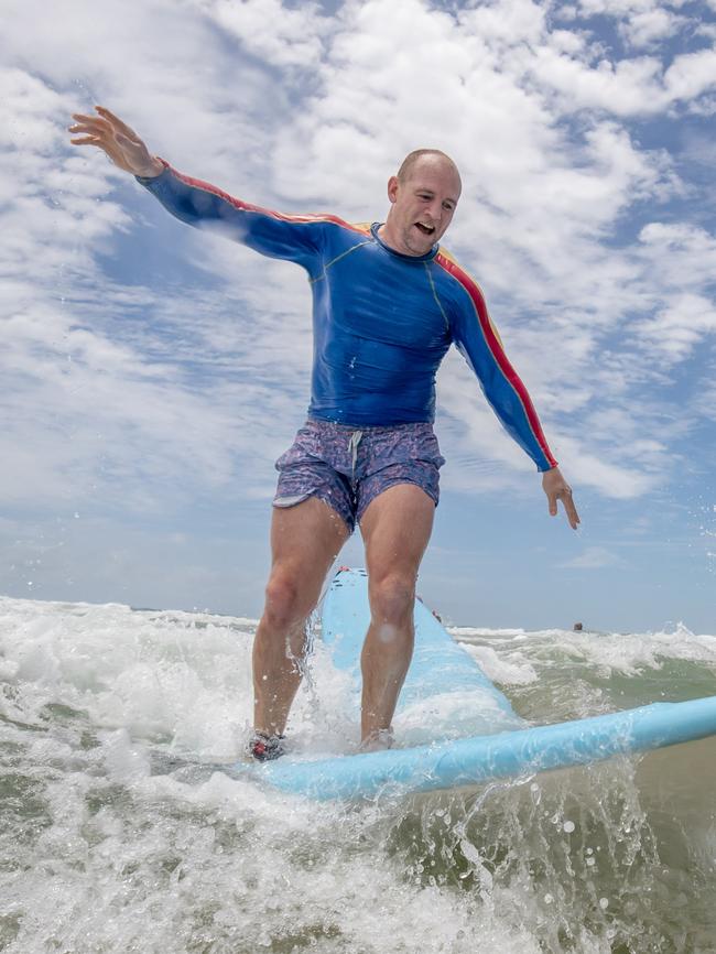 And trying his hand at surfing on an earlier trip to Australia.