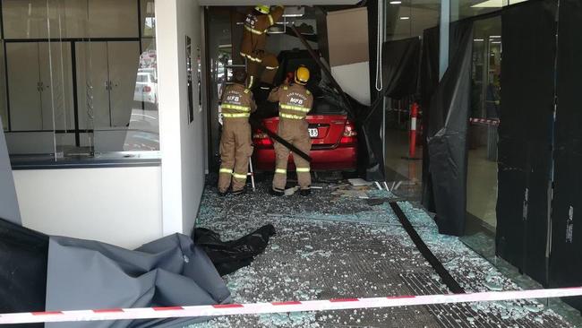 Firefighters prepare to remove the car from Bulleen Plaza.