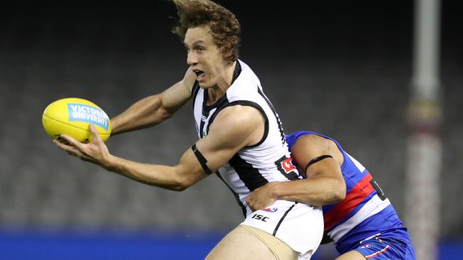 Chris Mayne gets a handball away as he’s tackled by Ben Cavarra. Picture: Michael Klein