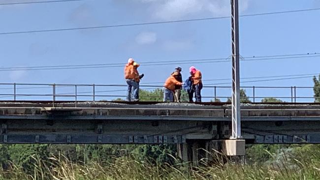 Police and Aurizon staff inspecting the train bridge at Gladstone where the incident occured.