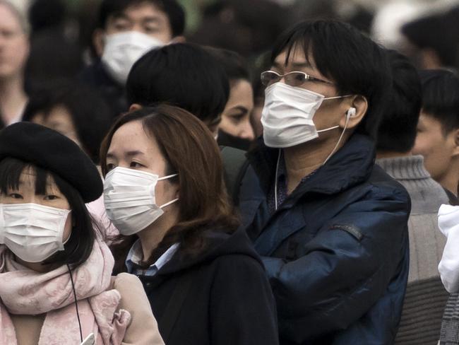 TOKYO, JAPAN - FEBRUARY 02: People wearing masks wait to cross a road  in the Shibuya district on February 02, 2020 in Tokyo, Japan. Japan reported 20 cases of Wuhan coronavirus infections as the number of those who have died from the virus, known as 2019-nCoV, in China climbed to over 300 and cases have been reported in other countries including the United States, Canada, Australia, Japan, South Korea, India, the United Kingdom, Germany, France, and several others.  (Photo by Tomohiro Ohsumi/Getty Images) *** BESTPIX ***