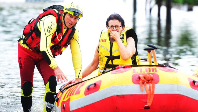 Tina Stephensen weeps as she is rescued from her home in flood-hit Hermit Park, Townsville, yesterday. Picture: Zak Simmonds