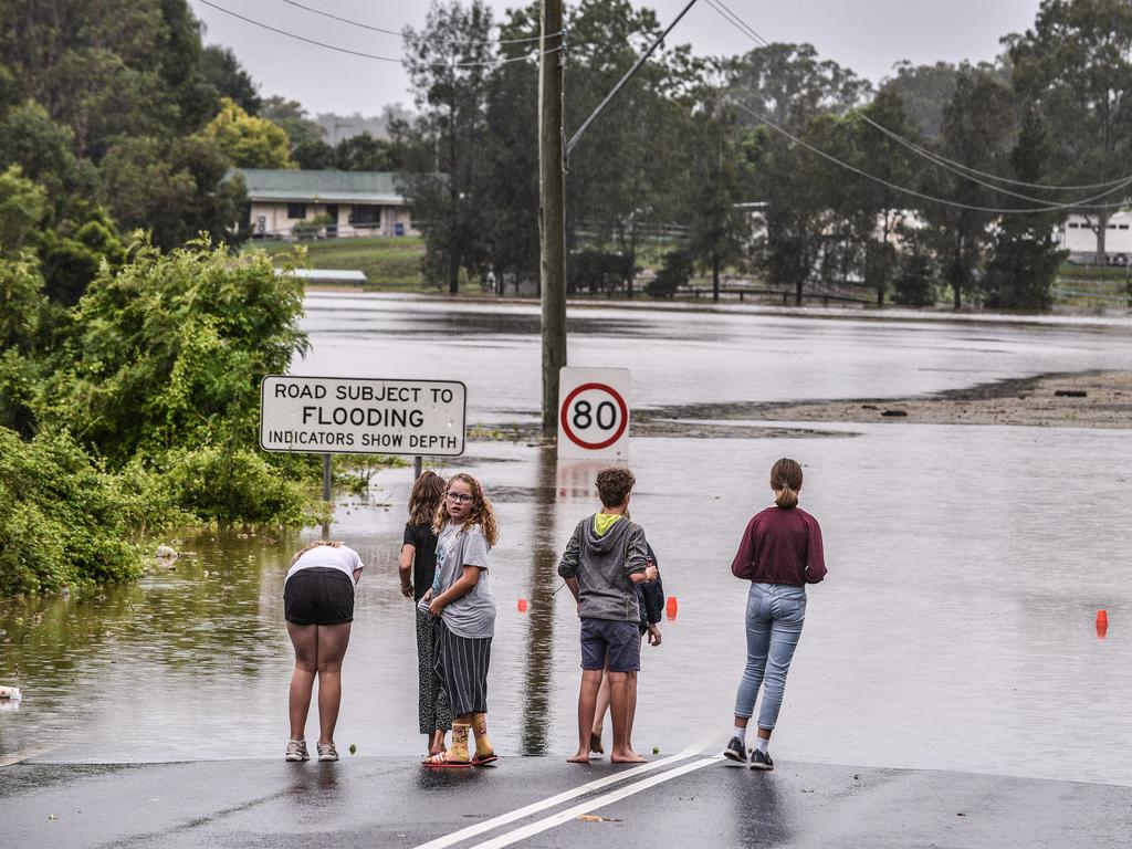 Local residents survey flooding at Pitt Town, McGraths Hill. Picture: NCA NewsWire/Flavio Brancaleone