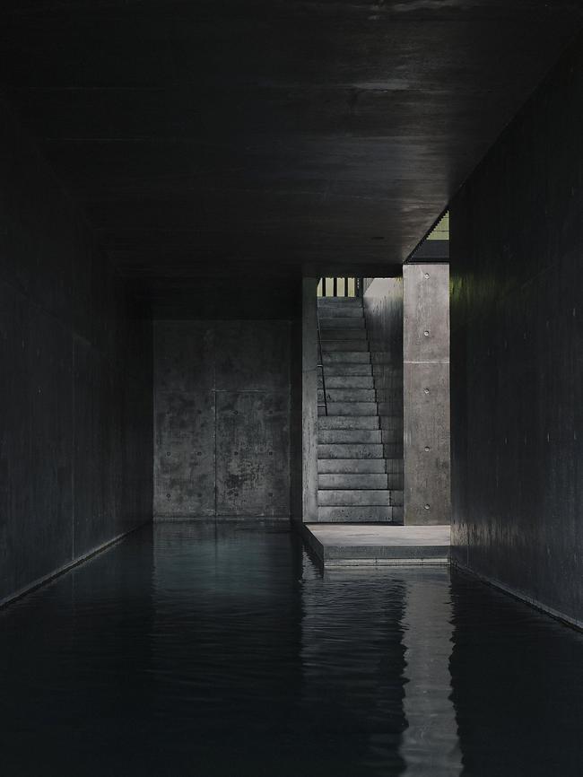 The sheltered black-concrete subterranean pool, linked to a planted void at the heart of the home. Picture: Ben Hosking.